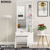 A white polished dressing table with a mirror, model BFT210, displayed in a room setting with decorative items and a plant beside it.